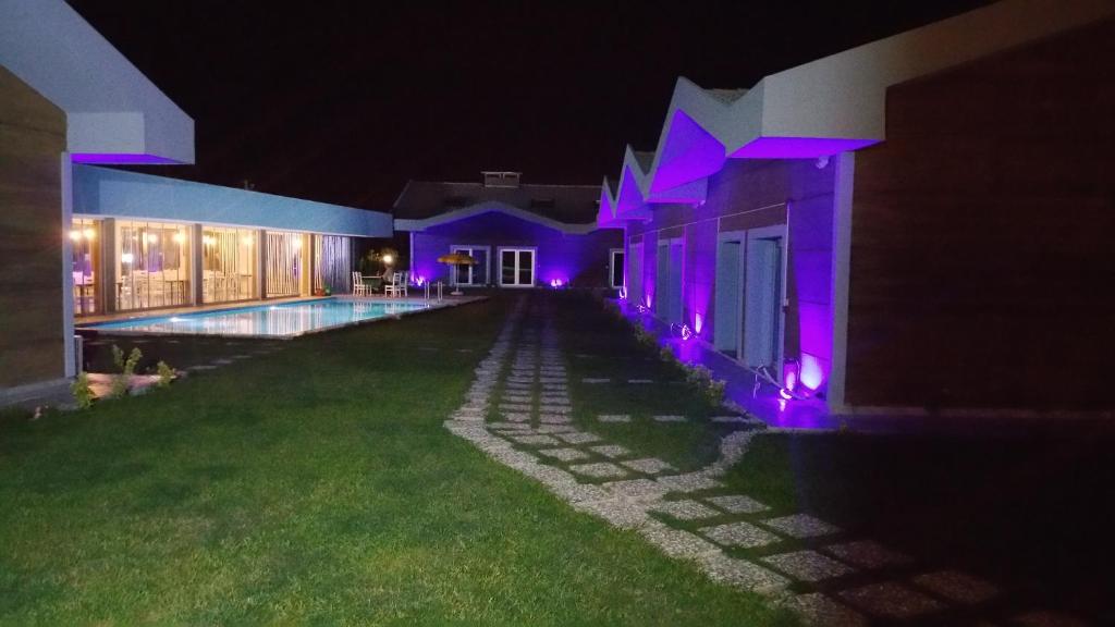 una casa iluminada por la noche con luces púrpuras en La Vida Hotel, en Urla