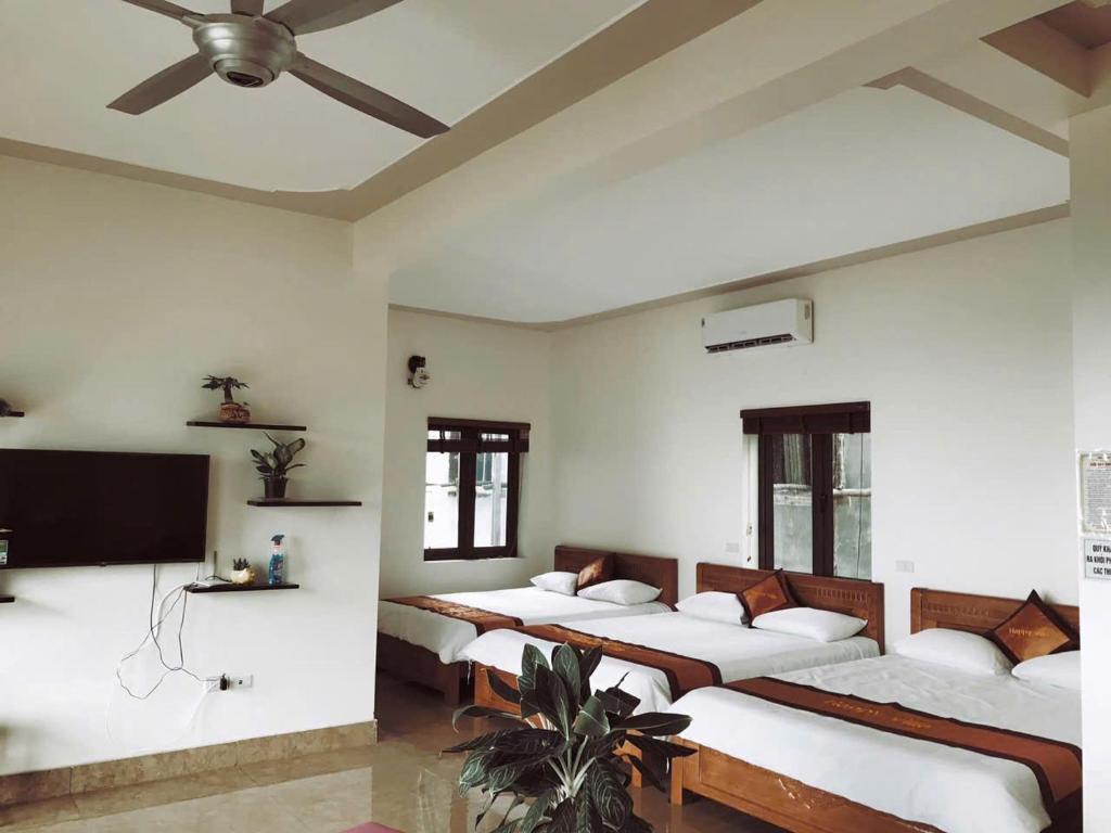 a room with four beds and a flat screen tv at Happy Villa Tam Đảo in Tam Ðảo