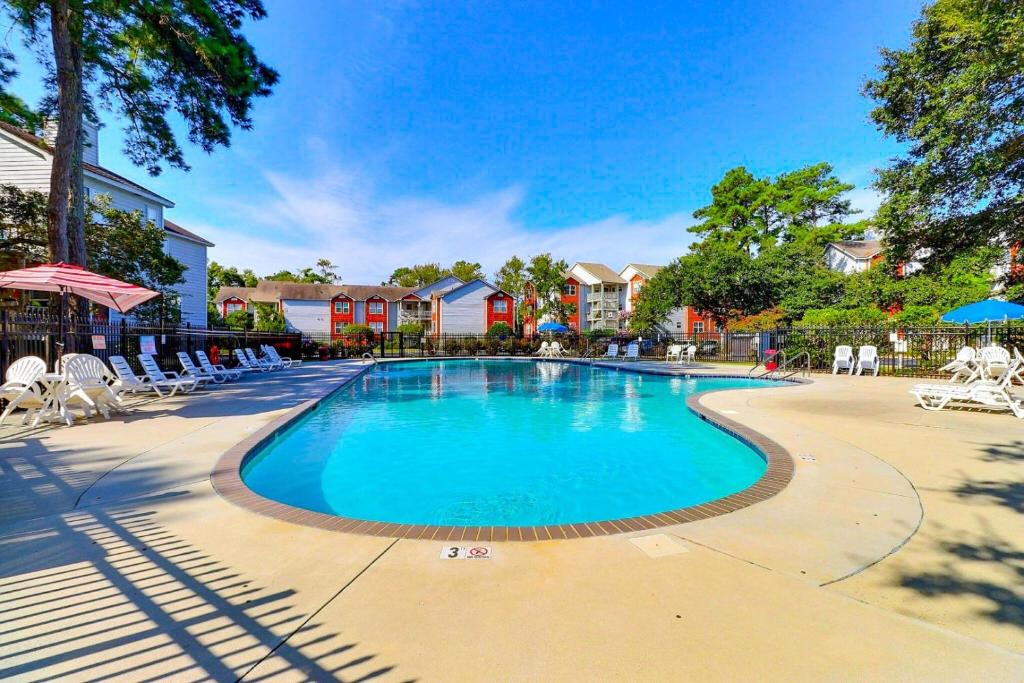 a swimming pool at a resort with chairs and trees at OYG6 - Peace of Paradise in Kill Devil Hills