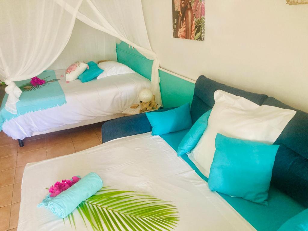 a room with two beds with blue and white at TIKAZADAPH, pour un séjour de charme, romantique & exotique, 97180 Sainte-Anne in Sainte-Anne