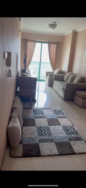 a living room with two beds and a checkered rug at apartement cempaka mas in Jakarta