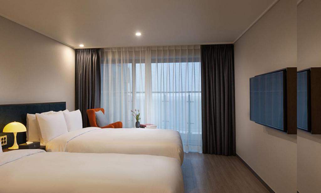 Postel nebo postele na pokoji v ubytování Busan Yeongmu Parade Hotel Haeundae Beach