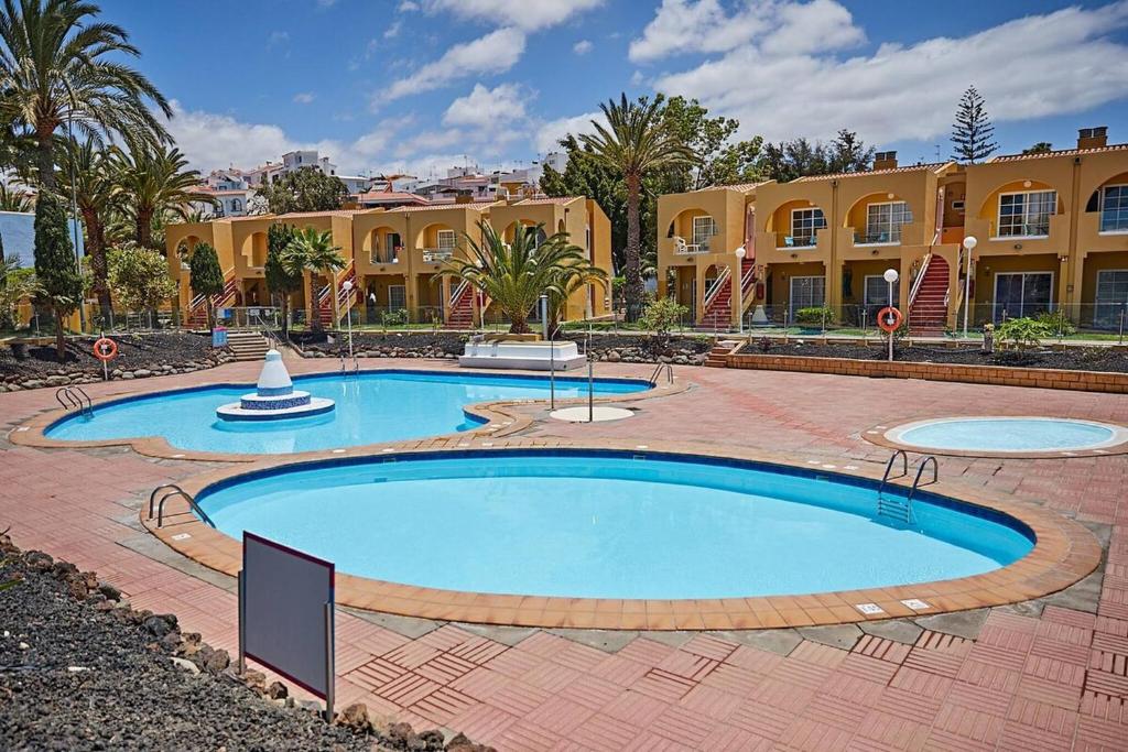 dwa baseny na dziedzińcu z budynkiem w obiekcie Apartament Tisalaya 44 By Pride Holiday Rentals w mieście Maspalomas
