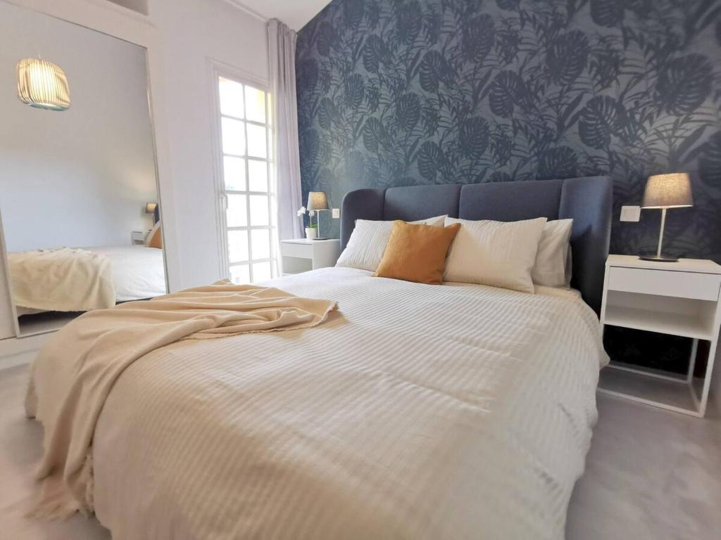 sypialnia z dużym białym łóżkiem z niebieską ścianą w obiekcie Apartament Tisalaya 44 By Pride Holiday Rentals w mieście Maspalomas