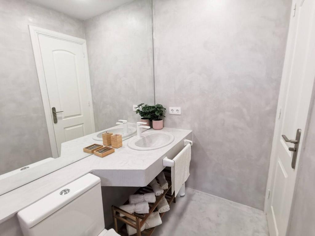 biała łazienka z umywalką i lustrem w obiekcie Apartament Tisalaya 44 By Pride Holiday Rentals w mieście Maspalomas