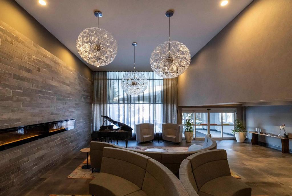 Una sala de estar con dos lámparas de araña y un piano. en Georgian Bay Hotel Trademark Collection by Wyndham, en Collingwood