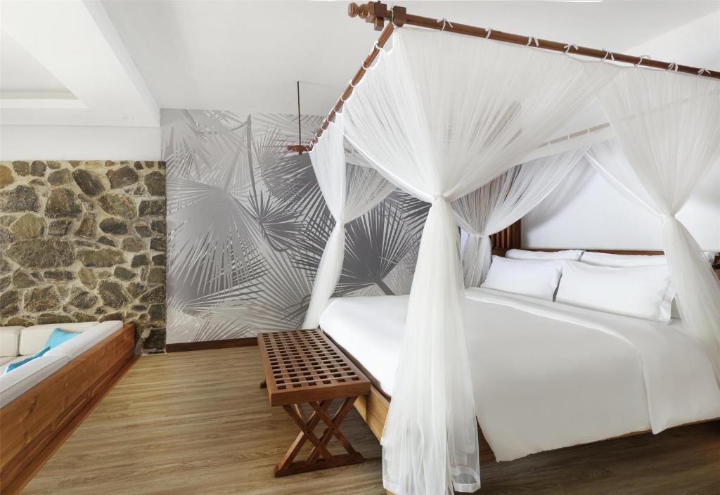 Postel nebo postele na pokoji v ubytování Kempinski Seychelles Resort
