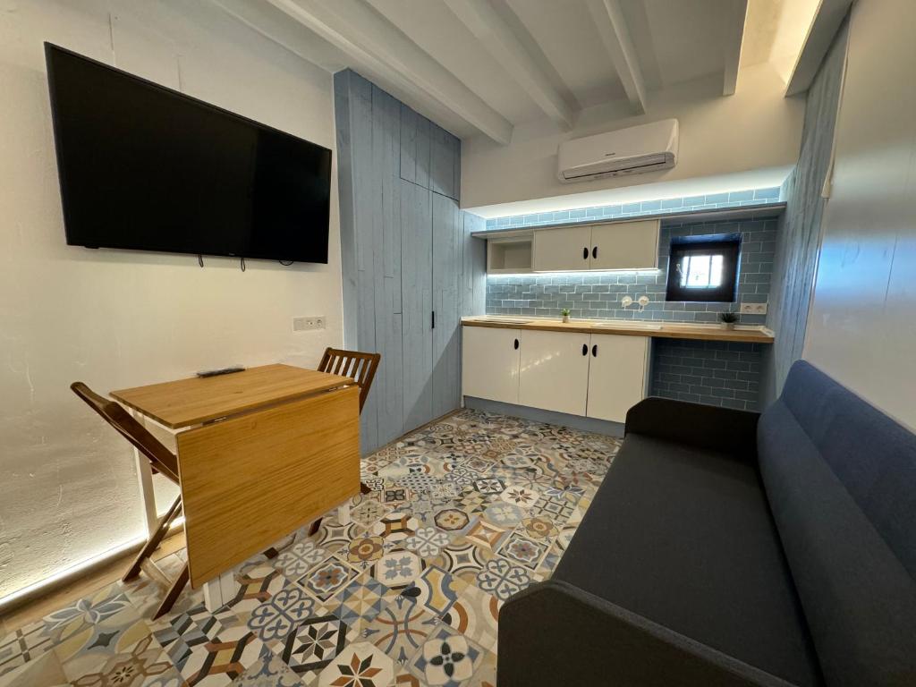 a living room with a desk and a tv on the wall at Viura - Harbor's Light in Villajoyosa