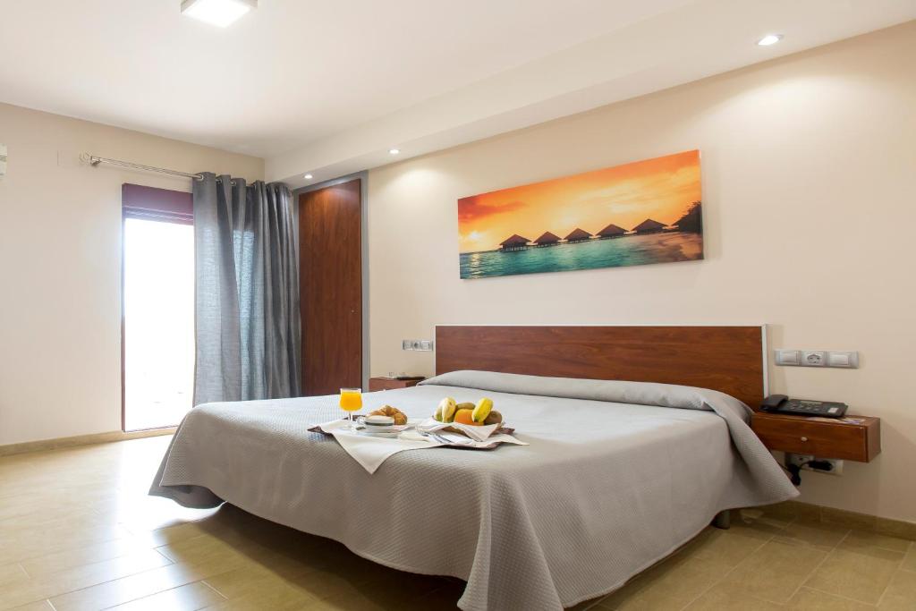 - une chambre avec un lit et un plateau de fruits dans l'établissement Hotel Olympia Ronda I, à El Puig