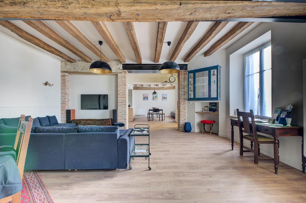 a living room with a blue couch and a table at Maison des Sources Touraine -SPA- in Esvres