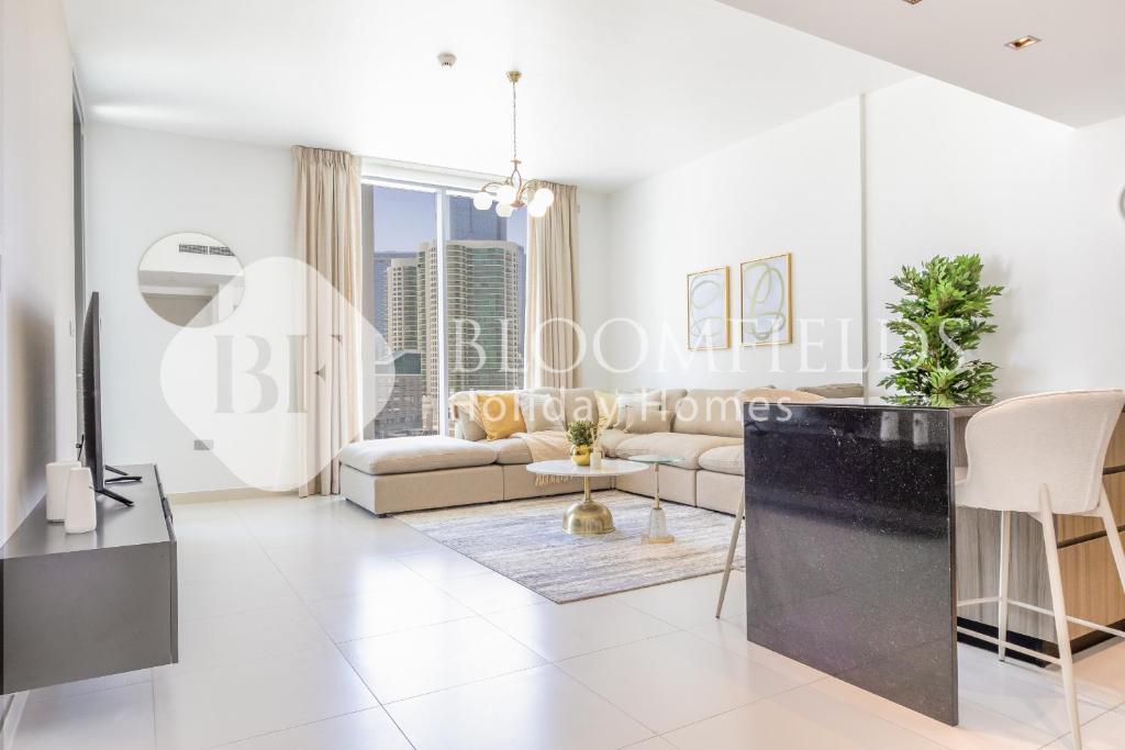 a living room with a couch and a tv at Bloomfields 1BR Elegant in Shams Meera in Abu Dhabi