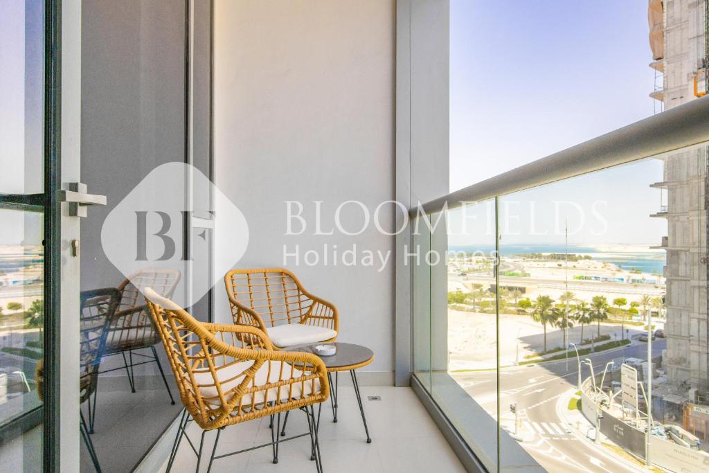 a balcony with two chairs and a table with a view at Bloomfields 1BR Elegant in Shams Meera in Abu Dhabi