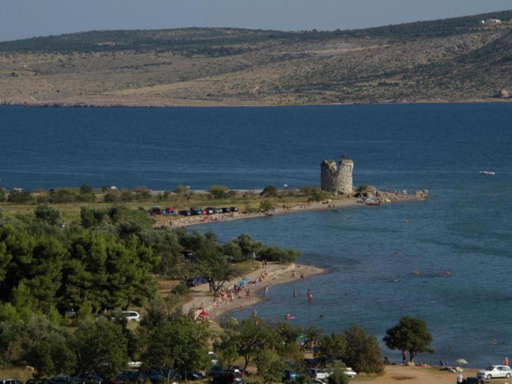 grupa ludzi na plaży z wieżą w wodzie w obiekcie Holiday Home in Starigrad near Paklenica w mieście Starigrad-Paklenica