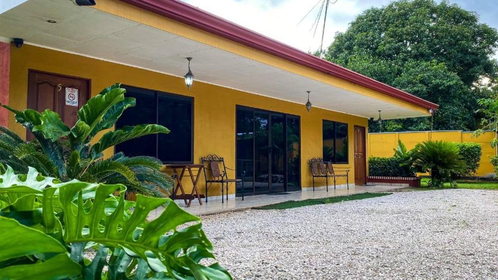 a yellow house with some chairs in front of it at Cabinas Liz in Veintisiete de Abril