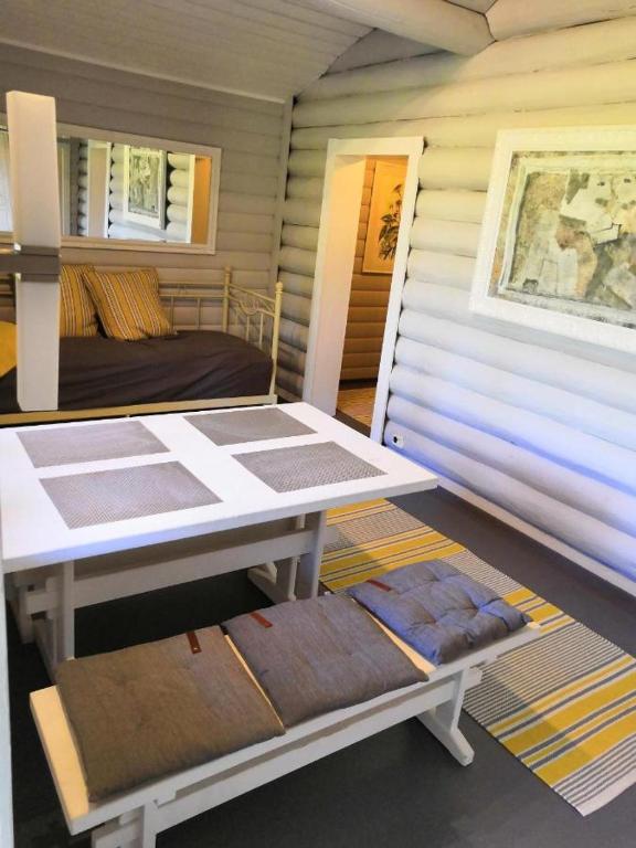 a room with a bed and a table and a bench at Koljonvirta Cottages in Iisalmi