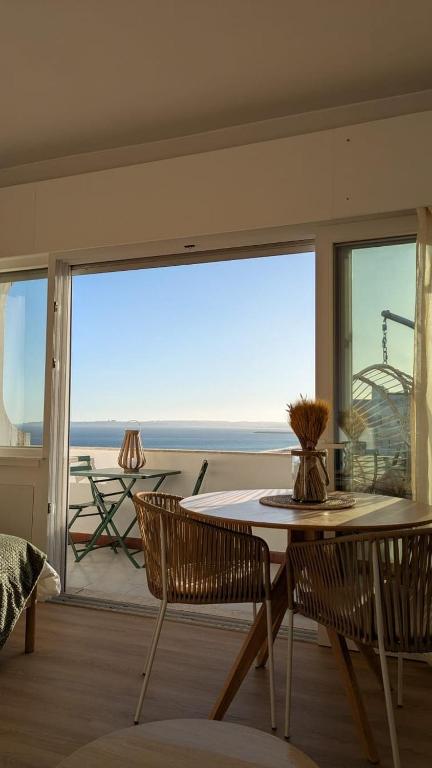 a dining room with a table and a view of the ocean at Penthouse Studio Sea View in Alvor