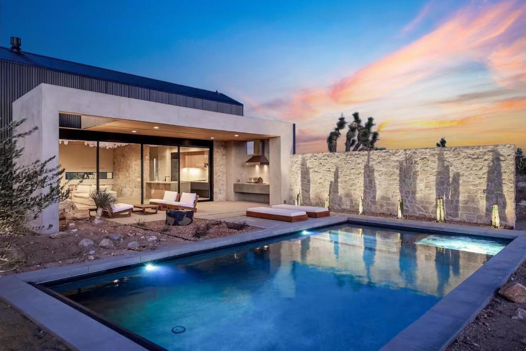 a swimming pool in front of a house at Ren House Luxury Nature Retreat in Yucca Valley