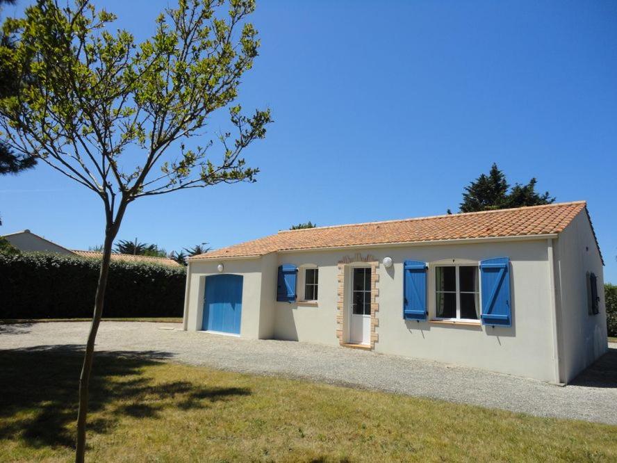 Une petite maison blanche avec des volets bleus dessus dans l'établissement Jolie maison de vacances secteur Mouettes, à Saint-Jean-de-Monts