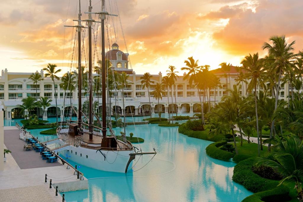 a boat in the water in front of a resort at Iberostar Grand Bavaro Hotel in Punta Cana