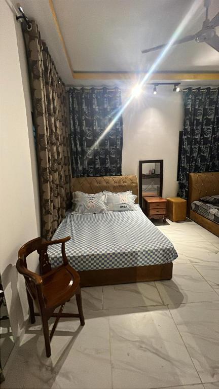 una camera con un letto e una sedia di Dian a Muadzam Shah