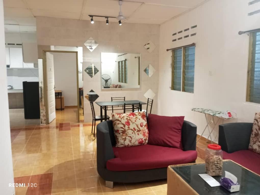un soggiorno con un divano rosso e un tavolo di Dian a Muadzam Shah
