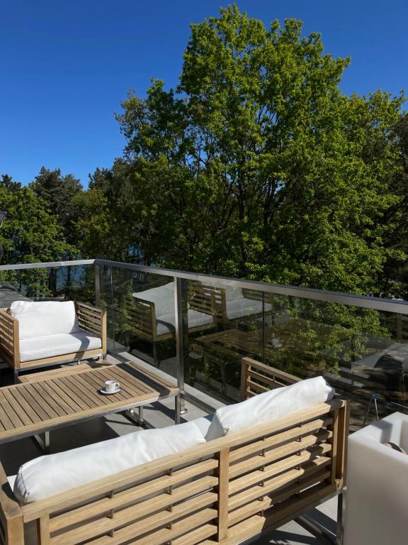 a deck with chairs and a table on a balcony at Apartament Dwie Sosny Patrycja in Ustronie Morskie