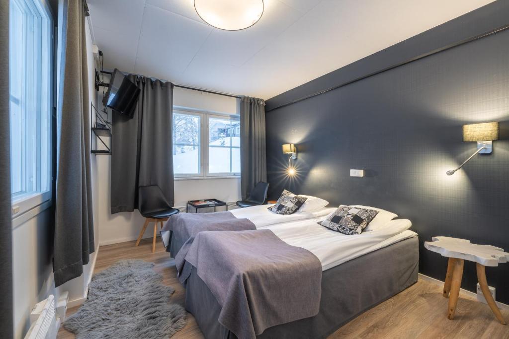 a hotel room with two beds and a window at Kuukkeli Saariselkä Inn in Saariselka