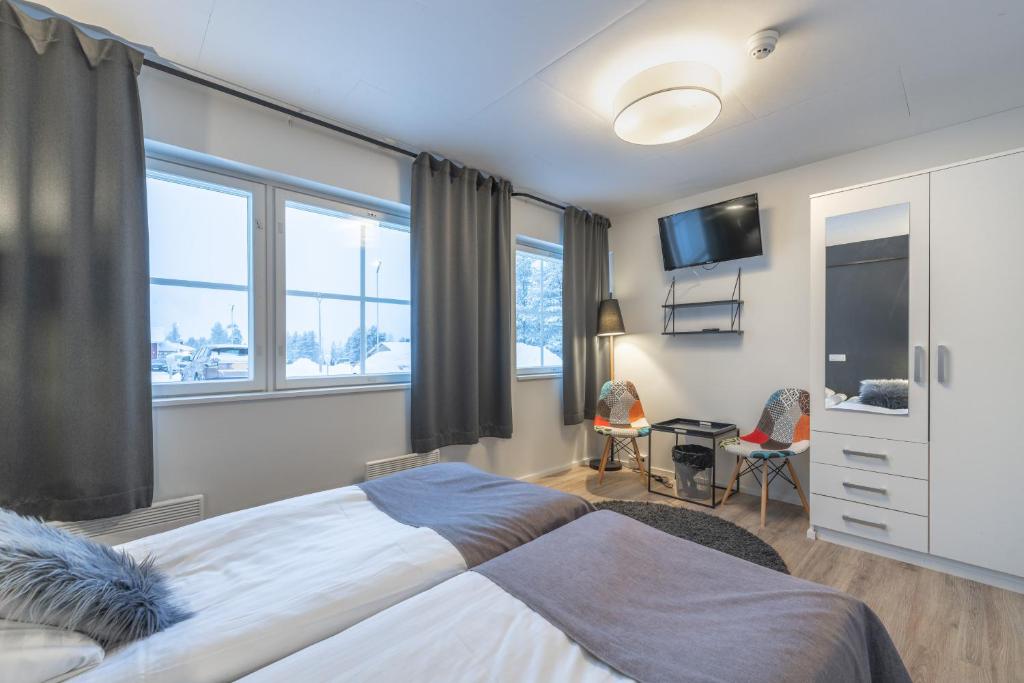 a bedroom with a large bed with a tv on the wall at Kuukkeli Saariselkä Inn in Saariselka