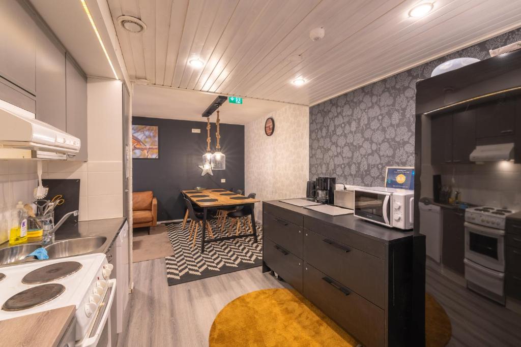 a kitchen with a sink and a microwave and a table at Kuukkeli Saariselkä Inn in Saariselka