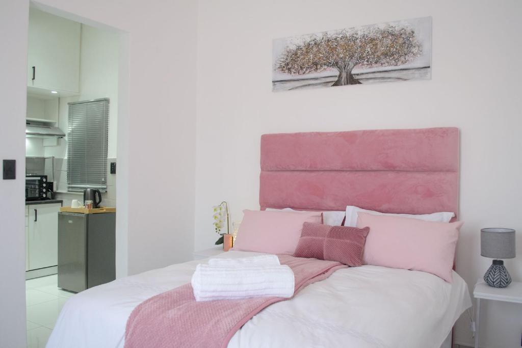 a bedroom with a bed with pink and white pillows at The View Apartment 3 in Lüderitz