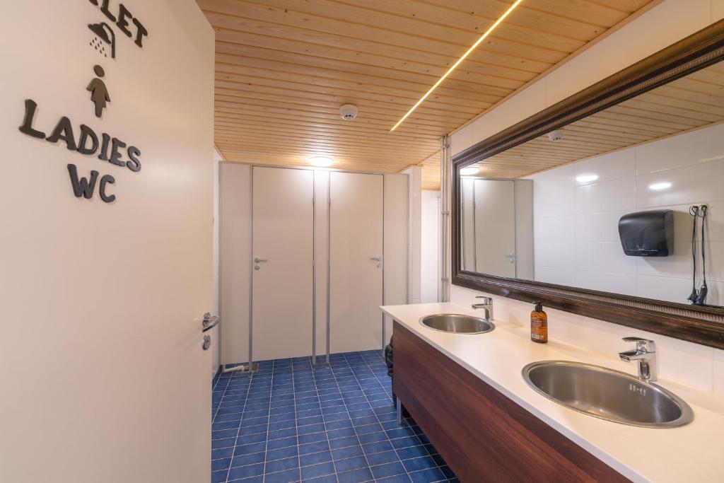 a bathroom with two sinks and a large mirror at Kuukkeli Saariselkä Inn in Saariselka