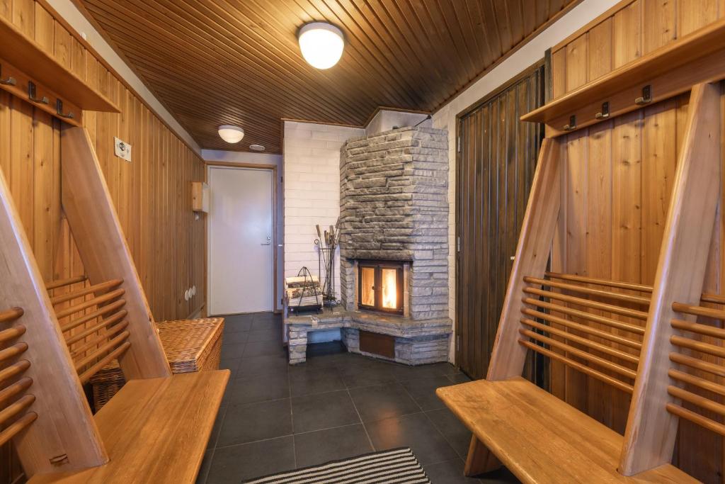 a hallway with benches and a fireplace in a house at Kuukkeli Saariselkä Inn in Saariselka