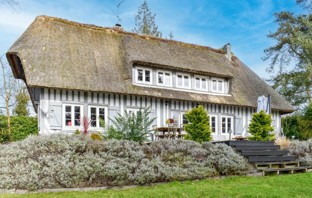 Ce cottage blanc ancien dispose d'un toit de chaume. dans l'établissement Chaumière Normande, à Le Breuil-en-Auge