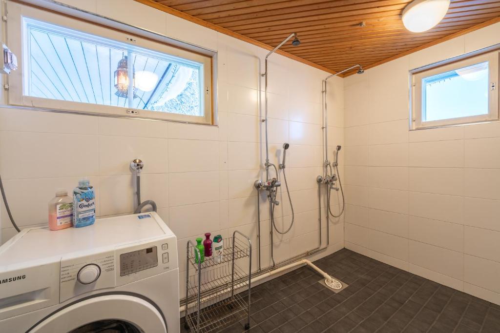 a washing machine in a bathroom with a window at Kuukkeli Saariselkä Inn in Saariselka