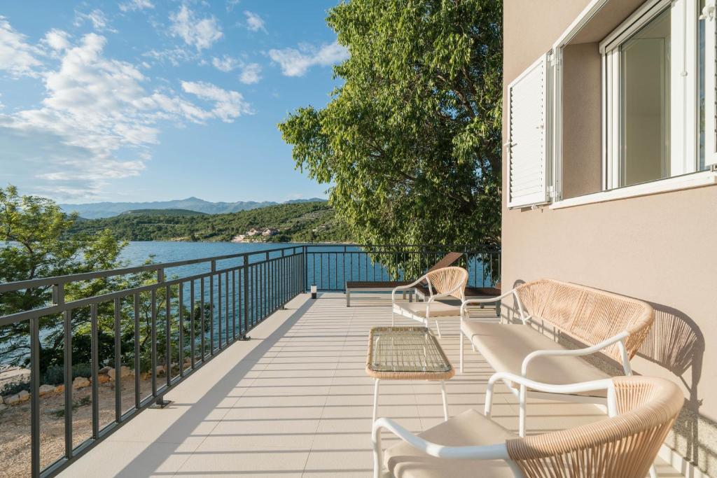 a balcony with chairs and a view of the water at Mekenzi - new apartments by the sea in Kruševo