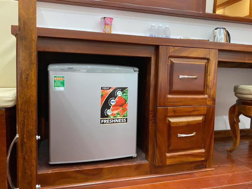 a small refrigerator sitting in a cabinet in a kitchen at Pandora Hotel Cần Thơ in Can Tho