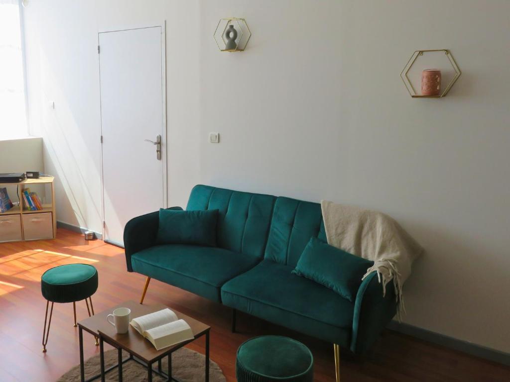 - un salon avec un canapé vert et des tabourets dans l'établissement Appartement rénové 2 chambres 55m2 Parking Privé et Wifi, à Troyes