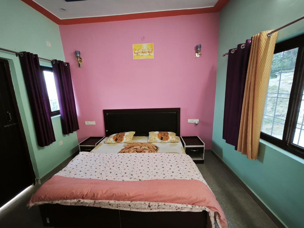 ランズドーンにあるDream Land Homestayのピンクの壁の大きなベッドのある寝室