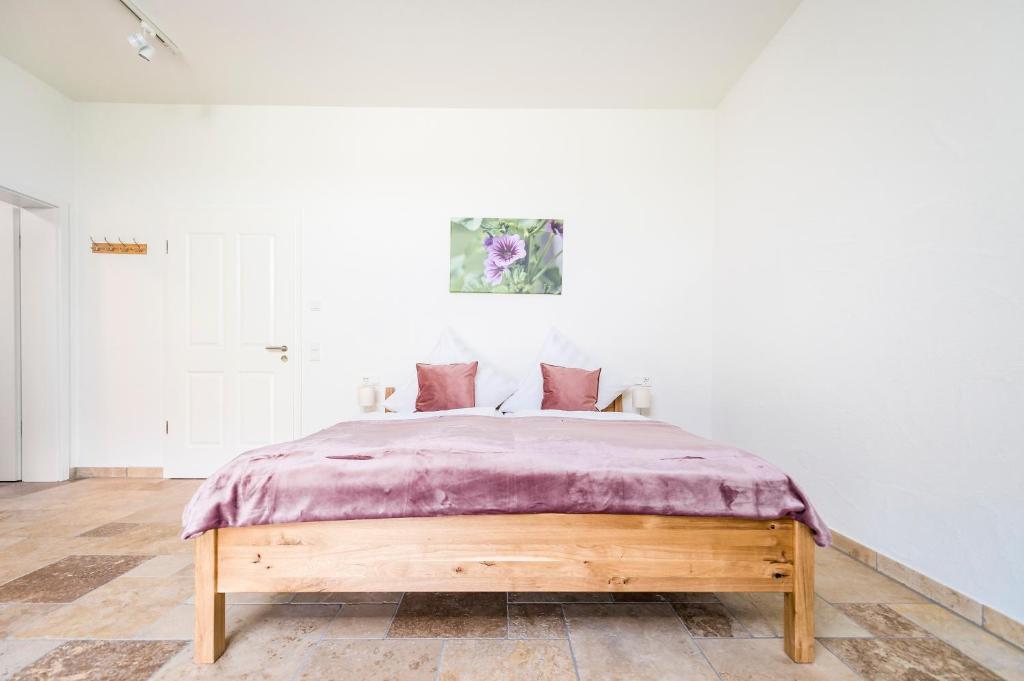 a bedroom with a bed with a purple blanket at Hofgut Dösterhof - Hotelzimmer in Wadern