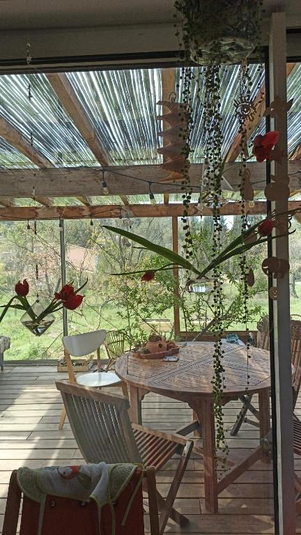 - une table et des chaises en bois sur une terrasse couverte avec un plafond en bois dans l'établissement Petite maison d'artitstes en Provence, à Auriol