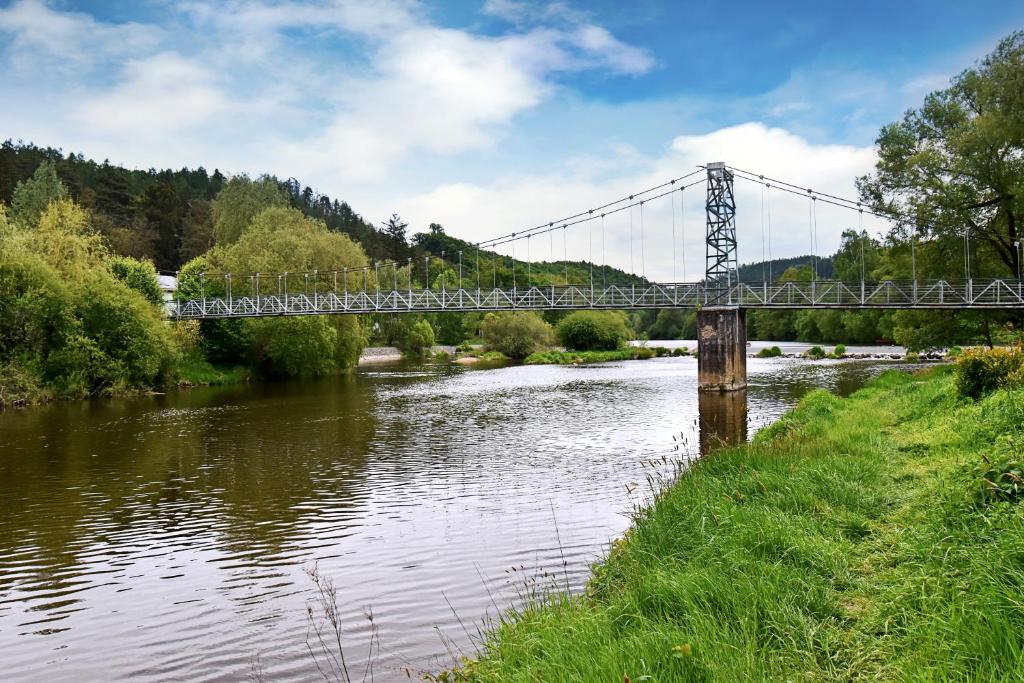 un ponte sopra un fiume con un treno che lo attraversa di Apartmány & Kemp Sázavský ostrov a Sázava