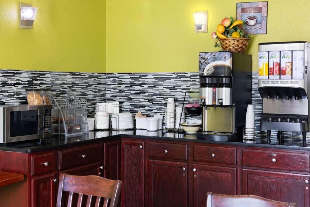 a kitchen with a counter top with a coffee shop at Super 8 by Wyndham South Boston VA in South Boston