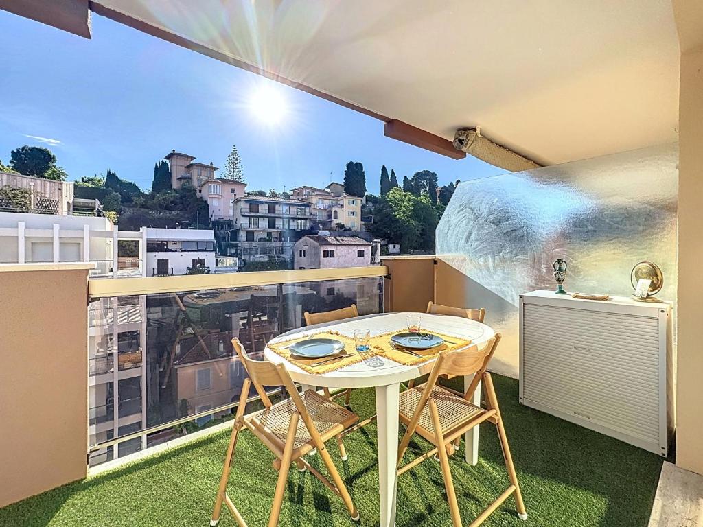 une table et des chaises sur un balcon avec vue dans l'établissement Hello Menton, à Menton