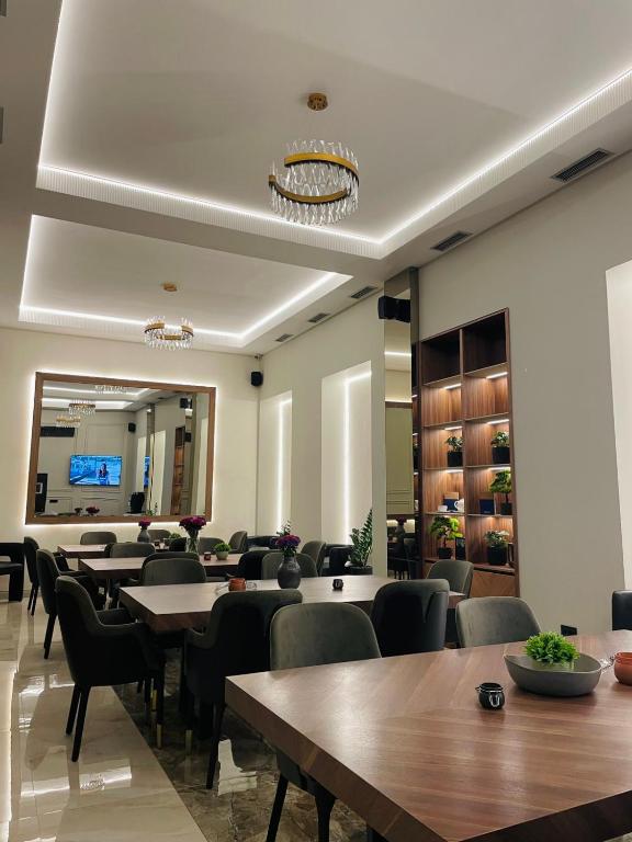a restaurant with tables and chairs and a mirror at Move In Aparthotel in Belgrade