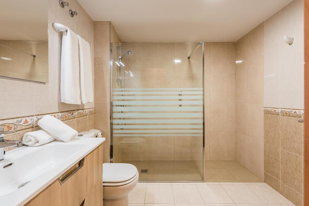 a bathroom with a shower and a toilet and a sink at Macdonald Doña Lola Resort in La Cala de Mijas