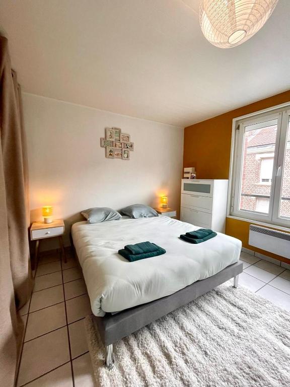 a bedroom with a large bed with two towels on it at L épicentre Gare d Amiens in Amiens