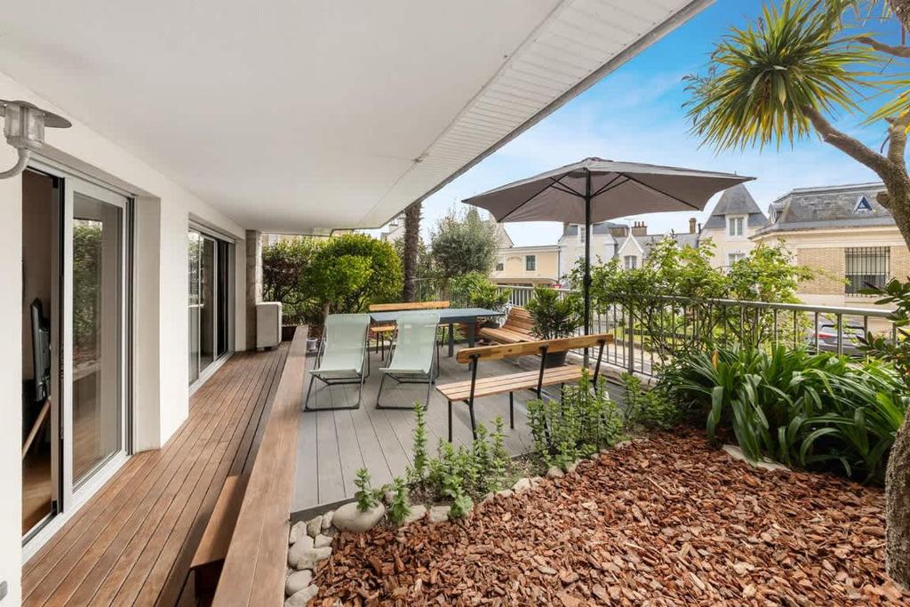 une terrasse avec une table et un parasol dans l'établissement Clémenceau - Centre Dinard - Terrasse/plage 50m, à Dinard