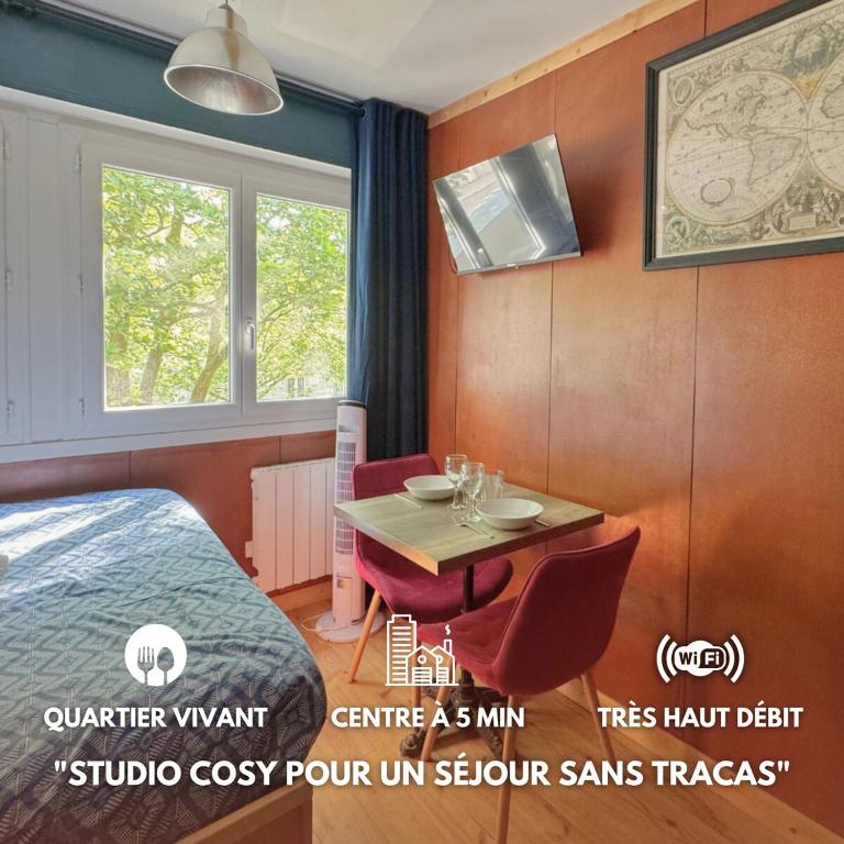 Cette chambre comprend une table, un lit et une fenêtre. dans l'établissement Le Yacht - Elégant et optimisé, à Lorient