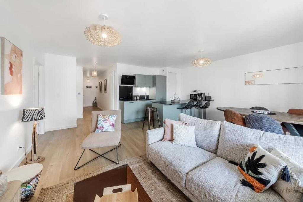 un salon avec un canapé et une cuisine dans l'établissement Rivage - Beau 2 chambres - Parking/Plage 300m, à Dinard