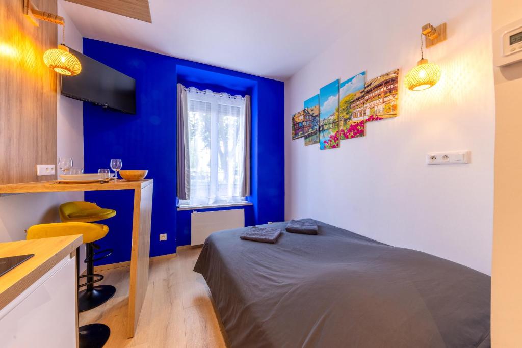 - une chambre aux murs bleus et un lit dans un dortoir dans l'établissement Suite - Strasbourg Gare - Petite France - Commerces à Proximité, à Strasbourg